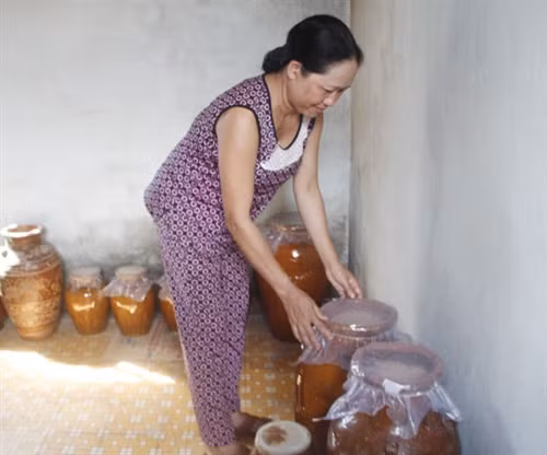 Bà H’Ben kiểm tra các ché rượu cần đang ủ