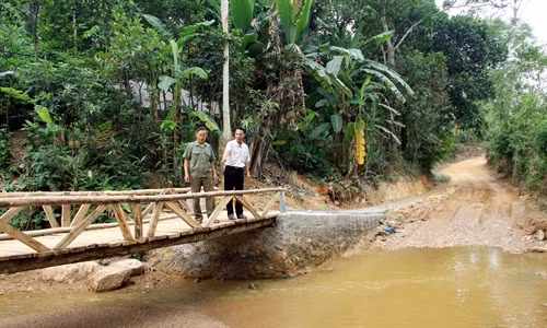Ông Chu Văn Diu (phải) kiểm tra độ an toàn của cây cầu gỗ sau một thời gian sử dụng.