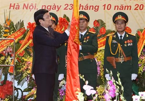 Chủ tịch nước Trương Tấn Sang gắn Huân chương Quân công hạng Nhất lên Quân kỳ Quyết thắng của Tổng cục Tình báo Quốc phòng Việt Nam. Ảnh: Nguyễn Khang – TTXVN