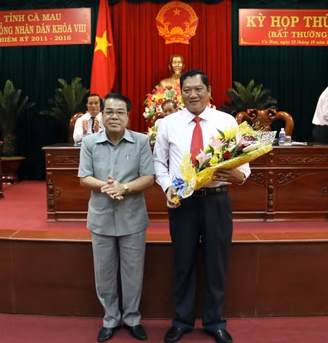 Bí thư Tỉnh ủy Cà Mau Dương Thanh Bình tặng hoa chúc mừng ông Lâm Văn Bi. Ảnh: Kim Há-TTXVN