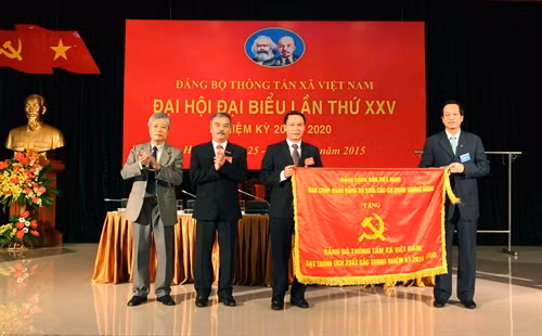 Đồng chí Đào Ngọc Dung trao Cờ thi đua của Đảng bộ khối cho Đảng bộ TTXVN vì đã có thành tích xuất sắc trong nhiệm kỳ 2011 – 2015. Ảnh: Quý Trung- TTXVN