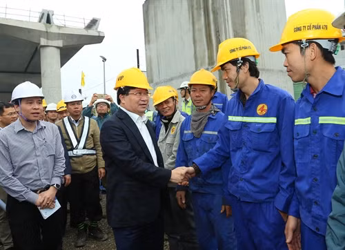 Phó Thủ tương Trịnh Đình Dũng với công nhân đang thi công tại dự án đường sắt đô thị Nhổn – Ga Hà Nội. Ảnh: Huy Hùng – TTXVN