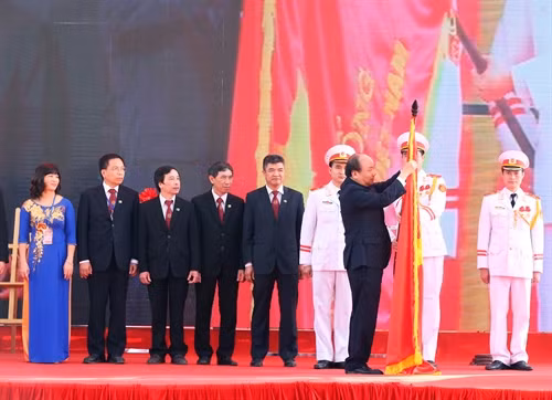 Thủ tướng Nguyễn Xuân Phúc gắn Huân chương Hồ Chí Minh lên Cờ truyền thống của Học viện Nông nghiệp Việt Nam. Ảnh: Thống Nhất – TTXVN