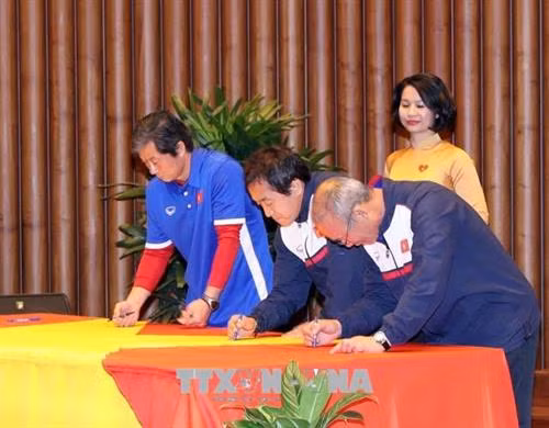 Lãnh đạo, huấn luyện viên, các cầu thủ đội bóng U.23 Việt Nam ký tên lên lá cờ Tổ quốc được Chủ tịch Quốc hội Nguyễn Thị Kim Ngân mang về từ Cột cờ Lũng Cú (Hà Giang). Ảnh: Trọng Đức - TTXVN