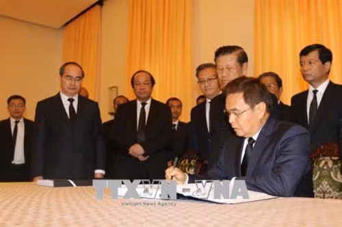 Chủ tịch Mặt trận Lào xây dựng đất nước Xay - xỏm - phôn Phôm - vi - hản viếng và ghi sổ tang nguyên Thủ tướng Chính phủ Phan Văn Khải. Ảnh: Thanh Vũ - TTXVN