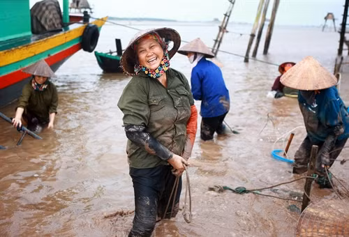 Một người phụ nữ tươi cười khi chuẩn bị hoàn tất ngày lao động vất vả.