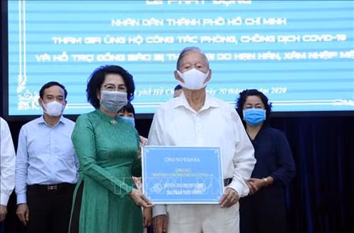 Tiếp nhận tượng trưng số tiền ủng hộ từ ông Võ Văn Ba, một người dân Thành phố Hồ Chí Minh. Ảnh: Xuân Khu-TTXVN