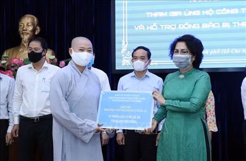 Tiếp nhận tượng trưng số tiền ủng hộ từ Ban Từ thiện-Xã hội, Giáo hội Phật giáo Việt Nam Thành phố Hồ Chí Minh. Ảnh: Xuân Khu-TTXVN