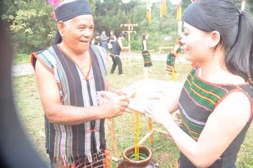Già làng trao vòng tay cầu chúc sức khỏe cho dân làng.
