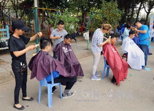Cắt tóc miễn phí cho các thiếu nhi tại công viên Khánh Hội, quận 4. Ảnh: An Hiếu - TTXVN