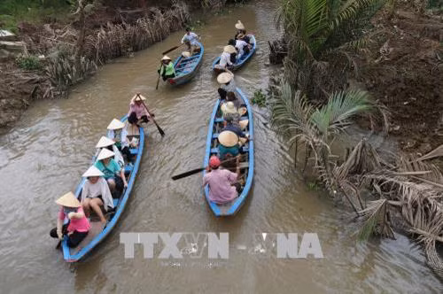 Khách du lịch tham quan miệt vườn sông nước ở cù lao Thới Sơn. Ảnh: Minh Trí - TTXVN