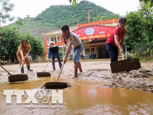 Giáo viên, phụ huynh trường Tiểu học Tân Lang, huyện Phù Yên dọn dẹp bùn đất trên sân trường. Ảnh: Hữu Quyết – TTXVN