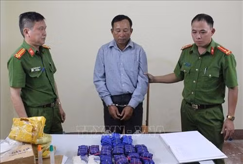 Đối tượng Mùa A Dê cùng tang vật tại cơ quan Công an. Ảnh: TTXVN phát.
