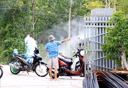 Phun thuốc tiêu độc khử trùng trước khi vào vùng dịch. Ảnh: Hồng Hiếu - TTXVN