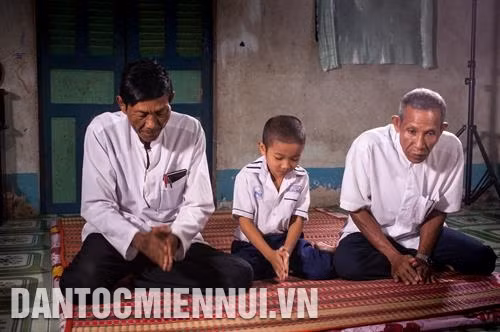 Cậu bé Sơn Quốc Thịnh, 7 tuổi, người dân tộc Khmer ở ấp An Hiệp, xã Phú Tâm, huyện Châu Thành (Sóc Trăng) đang học kinh với hai vị Achar. Ảnh: Văn Ngọc