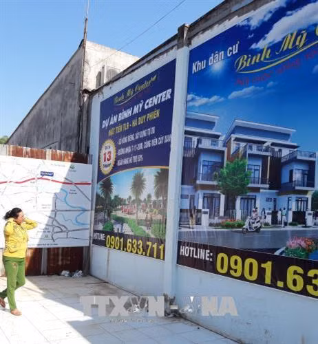 Biển hiệu quảng cáo "dự án" đất nền Bình Mỹ Center Tỉnh lộ 9, huyện Củ Chi. Ảnh: Trần Xuân Tình - TTXVN