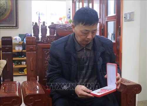 Thiếu tướng Trần Hữu Hoàn bên Huân chương Bảo vệ Tổ quốc hạng Nhất. Ảnh: Chu Hiệu – TTXVN