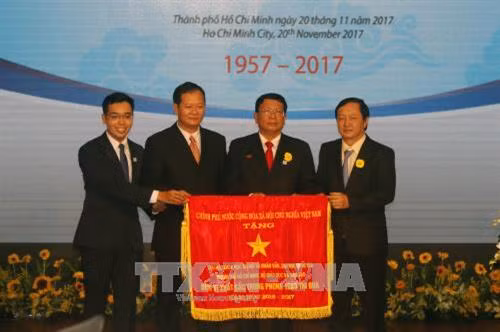 Thừa ủy quyền của Thủ tướng Chính phủ, Giám đốc Đại học Quốc gia Thành phố Hồ Chí Minh Huỳnh Thành Đạt trao Cờ Thi đua của Chính phủ cho trường Đại học Khoa học Xã hội và Nhân văn Thành phố Hồ Chí Minh. Ảnh: Hoàng Hải-TTXVN