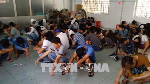 Các đối tượng sử dụng ma túy bị Công an tạm giữ. Ảnh: Thành Chung – TTXVN