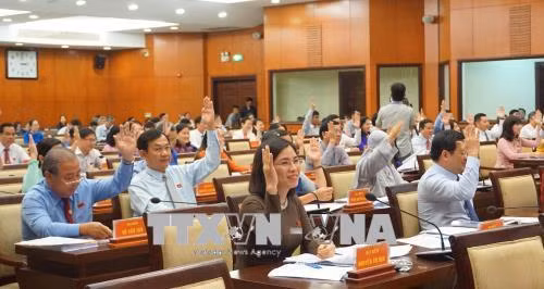 Các đại biểu thông qua nghị quyết của kỳ họp. Ảnh: Thu Hoài – TTXVN