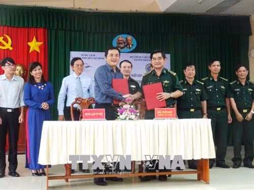 Ông Bùi Tá Hoàng Vũ, Giám đốc Sở Du lịch Thành phố Hồ Chí Minh và Đại tá Tô Danh Út, Chỉ huy trưởng Bộ Chỉ huy Bộ đội biên phòng Thành phố tại buổi ký kết. Ảnh: Gia Thuận - TTXVN