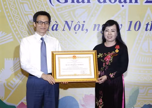 Phó Thủ tướng Vũ Đức Đam trao Huân chương Lao động hạng Ba của Chủ tịch nước cho Bộ trưởng Bộ Y tế Nguyễn Thị Kim Tiến- Trưởng ban Quân dân y kết hợp cấp Bộ vì đã có nhiều thành tích trong công tác kết hợp quân dân y chăm sóc sức khỏe bộ đội và nhân dân giai đoạn 2005 - 2015. Ảnh: An Đăng- TTXVN