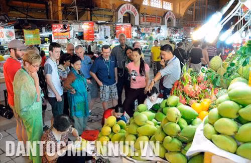 Du khách tham quan, tìm hiểu về các loại trái cây được bày bán tại chợ Bến Thành, thành phố Hồ Chí Minh. Ảnh: An Hiếu