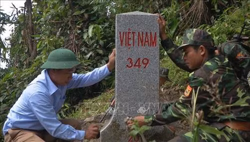 Ông Lò Văn Thọ, người có uy tín ở Bản Xắng, xã Yên Khương, huyện Lang Chánh làm vệ sinh cột mốc 349. Ảnh: Trịnh Duy Hưng-TTXVN