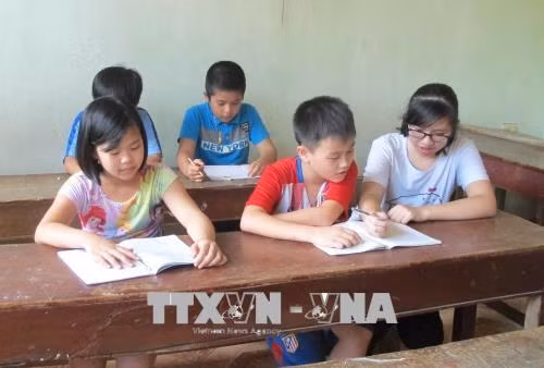 Lê Thị Minh Ngọc dạy tiếng Anh miễn phí cho các em nhỏ. Ảnh: Thùy Dung - TTXVN
