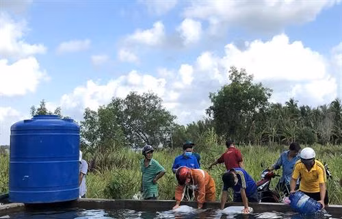 Người dân vùng hạn, mặn xã Thạnh Phú Đông, huyện Giồng Trôm, tỉnh Bến Tre vui mừng nhận nước ngọt được trao tặng. Ảnh: TTXVN phát
