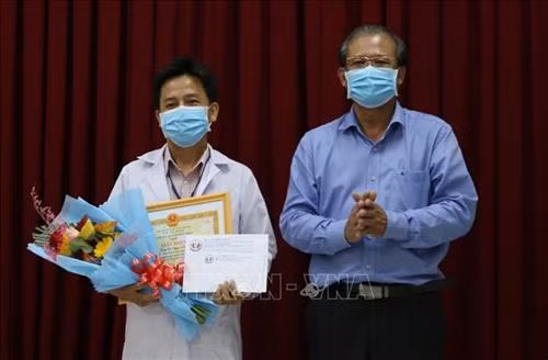 Bác sĩ chuyên khoa I Lê Ngọc Lâm - Khoa Ngoại tổng hợp, Bệnh viện Đa Khoa Sa Đéc, tỉnh Đồng Tháp (bên trái) được Giám đốc Sở Y tế tỉnh tuyên dương đột xuất về thành tích trong nghiên cứu, sáng tạo thành công “Robot vận chuyển phục vụ cho bệnh nhân khu cách ly”. Ảnh: Chương Đài - TTXVN