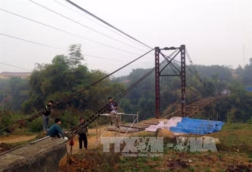 Coogn nhân Công ty TNHH Thành Long đang khẩn trương sửa chữa cầu treo Bình Yên (Tuyên Quang). Ảnh: Quang Đán- TTXVN