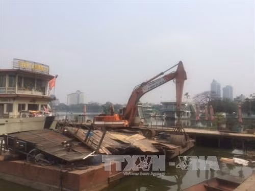 Lực lượng chức năng tháo dỡ bên nổi, nhà chờ khu vực số 2 phố Nguyễn Đình Thi. Ảnh: Nguyễn Thắng- TTXVN