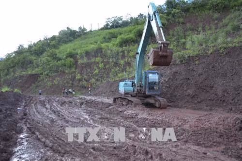 Đơn vị quản lý tuyến Quốc lộ 4H hiện đang dọn sạch bùn nhão trên nền đường, đảm bảo tốt nhất cho các phương tiện giao thông qua lại. Ảnh: Văn Dũng - TTXVN