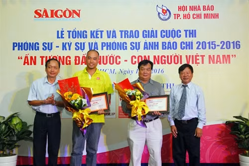 phóng Ban tổ chức trao giải Nhì cho các tác giả về thể loại Phóng sự ảnh. Ảnh: Mạnh Linh-TTXVN