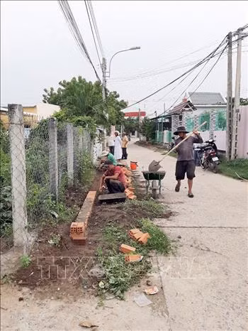 Đồng bào cùng sửa sang hệ thống đường giao thông nông thôn sạch đẹp để đón lễ hội Katê. Ảnh: Công Thử - TTXVN
