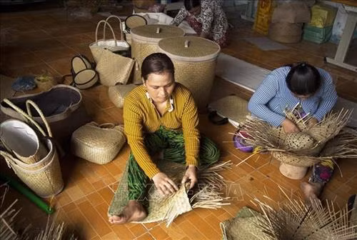 Bà con người Khmer làm các sản phẩm thủ công mỹ nghệ từ cỏ bàng. Ảnh: Hồng Đạt - TTXVN