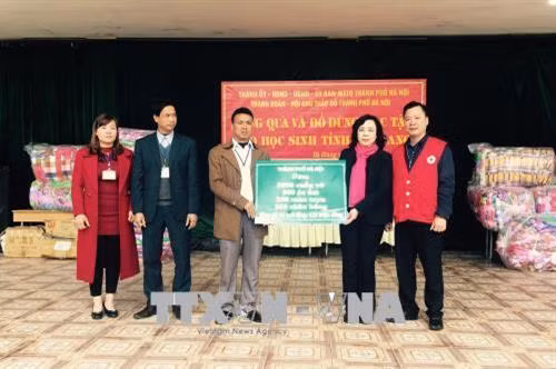 Phó Bí thư Thường trực Thành ủy Hà Nội trao tặng đồ dùng học tập cho các em học sinh tỉnh Hà Giang. Ảnh: Minh Tâm-TTXVN