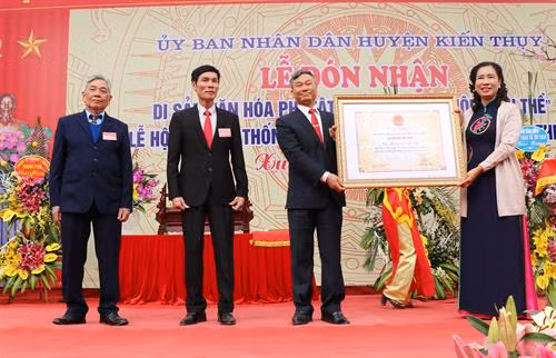 Bà Đặng Thị Bích Liên, Thứ trưởng Bộ Văn hóa Thể thao và Du lịch, trao Bằng công nhận “Di sản văn hóa phi vật thể quốc gia Hội Minh Thề” cho lãnh đạo huyện Kiến Thụy. Ảnh: Minh Thu-TTXVN