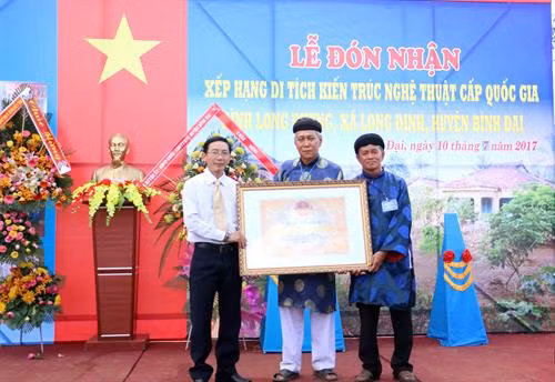 Ông Trương Quốc Phong (trái), Giám đốc Sở Văn hóa, Thể thao và Du lịch Bến Tre, trao Bằng công nhận di tích kiến trúc nghệ thuật cấp quốc gia Đình Long Phụng cho đại diện Ban khánh tiết Đình Long Phụng.