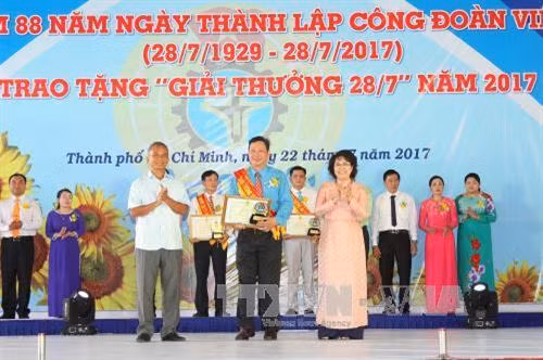 Nguyên Chủ tịch Tổng LĐLĐ Việt Nam Đặng Ngọc Tùng cùng lãnh đạo Thành phố Hồ Chí Minh trao bằng khen và biểu trưng chúc mừng Chủ tịch Công đoàn cơ sở tiêu biểu được nhận "Giải thưởng 28/7". Ảnh: Thanh Vũ-TTXVN