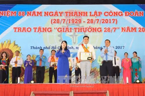 Lãnh đạo Thành phố Hồ Chí Minh trao bằng khen và biểu trưng chúc mừng Chủ tịch Công đoàn cơ sở tiêu biểu được nhận "Giải thưởng 28/7". Ảnh: Thanh Vũ-TTXVN