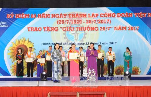 Lãnh đạo Thành phố Hồ Chí Minh trao bằng khen và biểu trưng chúc mừng Chủ tịch Công đoàn cơ sở tiêu biểu được nhận "Giải thưởng 28/7". Ảnh: Thanh Vũ-TTXVN