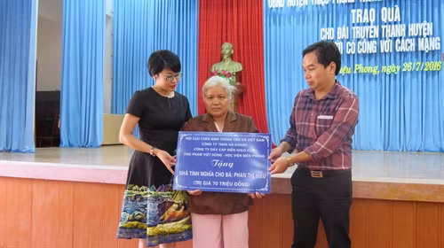 Các đại biểu trao tặng tượng trưng nhà tình nghĩa cho bà Phan Thị Hiển. Ảnh: Trần Tĩnh-TTXVN