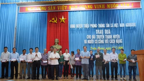 Đồng chí Nguyễn Đức Lợi trao sổ tiết kiệm cho các gia đình chính sách. Ảnh: Trần Tĩnh-TTXVN
