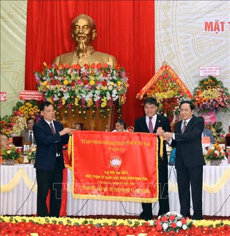 Đồng chí Trần Thanh Mẫn tặng bức trướng với dòng chữ "Đoàn kết - Dân chủ - Trí tuệ - Đổi mới và Phát triển" cho đồng chí Nguyễn Trung Hải, Chủ tịch Ủy ban mặt trận tổ quốc Việt Nam tỉnh Kon Tum lần thứ X, nhiệm kỳ 2019 - 2024. Ảnh: Quang Thái - TTXVN