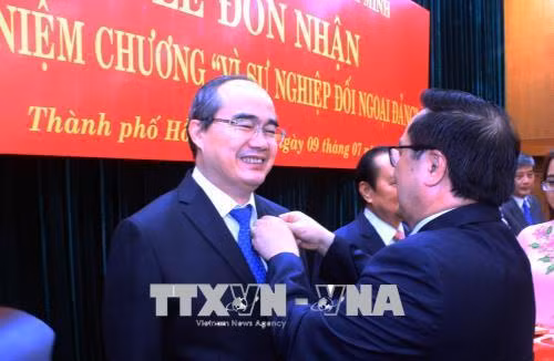 Đồng chí Hoàng Binh Quân, Ủy viên Trung ương Đảng, Trưởng ban Đối ngoại Trung ương gắn kỷ niệm chương "Vì sự nghiệp đối ngoại Đảng" cho đồng chí Nguyễn Thiện Nhân, Ủy viên Bộ Chính trị, Bí thư Thành ủy Thành phố. Ảnh: Xuân Khu-TTXVN
