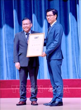 Đại diện QS Stars University Raitings (trái) trao chứng nhận xếp hạng 4 sao cho đại diện lãnh đạo Trường Đại học Tôn Đức Thắng. Ảnh: Thu Hoài - TTXVN