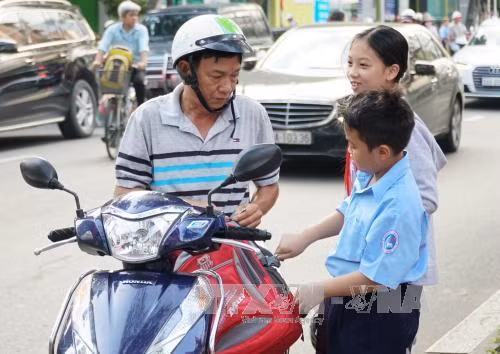 Phụ huynh đưa trẻ đến tựu trường năm học mới 2017-2018 tại trường Đinh Tiên Hoàng, Quận 1, Thành phố Hồ Chí Minh. Ảnh: Phương Vy - TTXVN