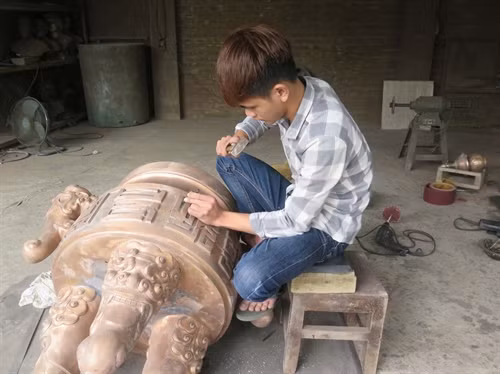 Một sản phẩm đang được người thợ làng nghề thực hiện sửa nguội, đục âm để khảm đồng.